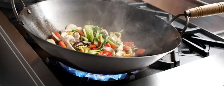 Picture of someone cooking vegetables in a wok